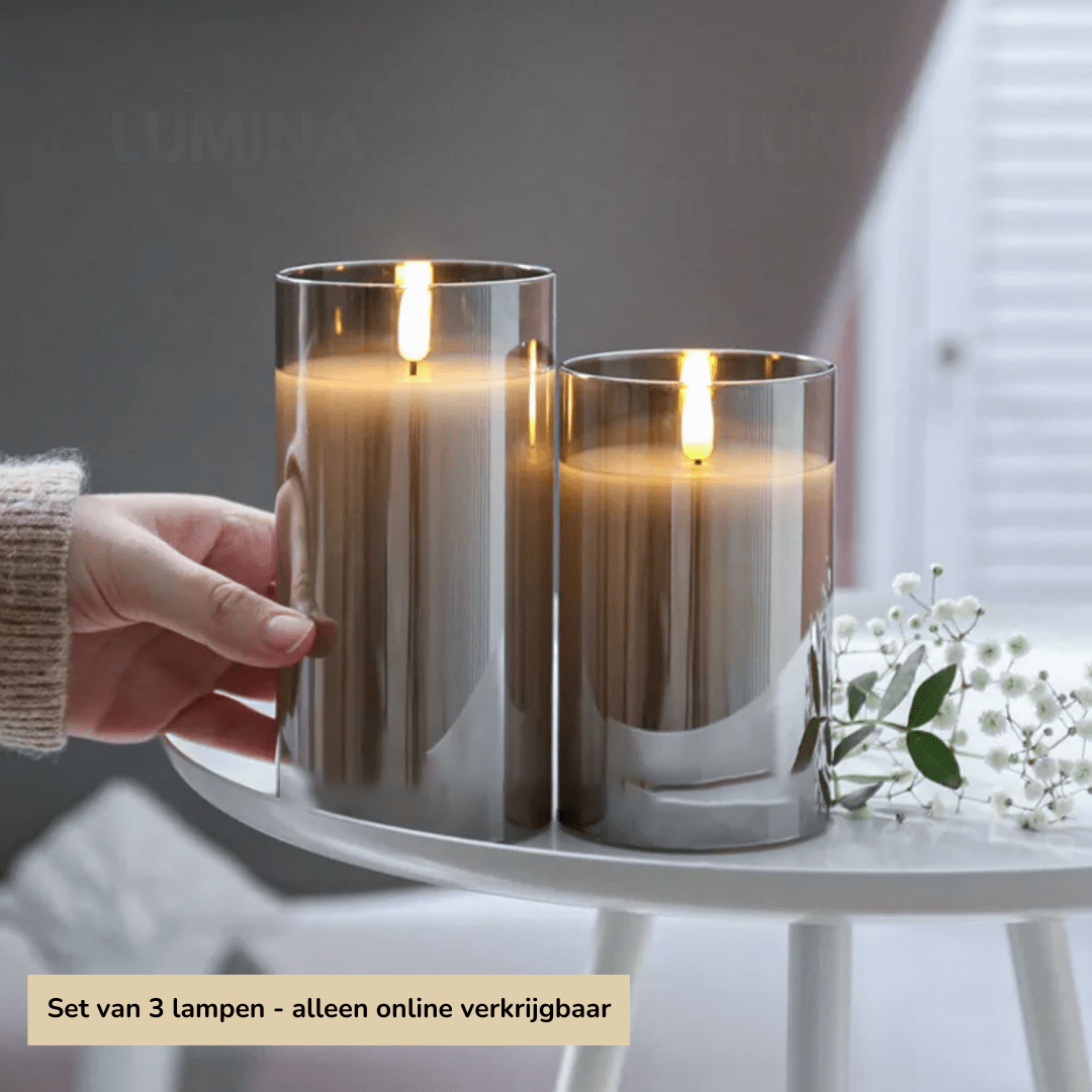 Zwei silberne LED-Kerzen auf Tisch, moderne Dekoration, warmes Licht, Wohnzimmer.