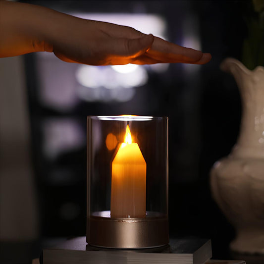 Hand über LED-Kerze in Glaszylinder, warmes Licht, moderne Dekoration, Wohnzimmerbeleuchtung.