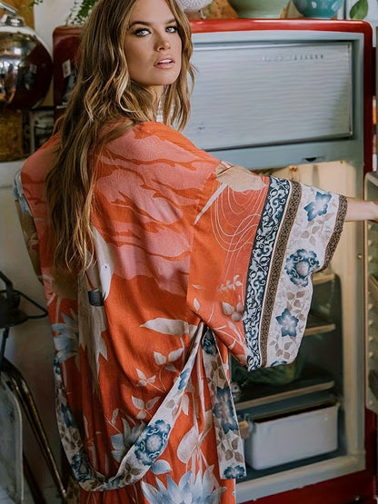 Frau in orangefarbenem Kimono mit Blumenmuster vor offenem Kühlschrank.