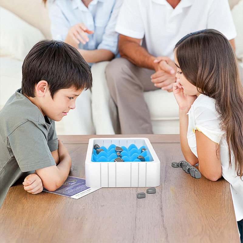 Zwei Kinder spielen mit einem weißen Tischspiel mit blauen und grauen Elementen im Wohnzimmer.