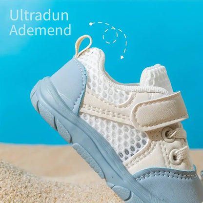 Beiger und blauer Kinderschuh, atmungsaktiv, mit Klettverschluss, auf Sandhintergrund.