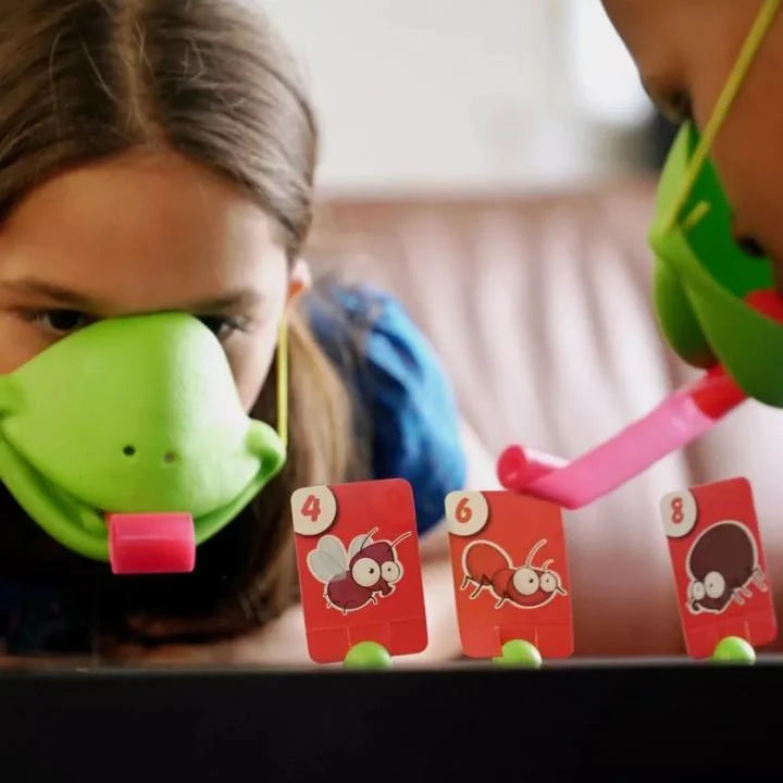 Kinder spielen mit Fliegenspiel, grüne Masken, rote Karten, lustiges Gesellschaftsspiel.