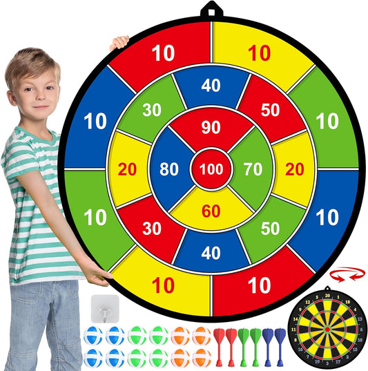 Junge mit großem buntem Wurfspiel-Dartboard, inklusive Pfeile, für Kinder drinnen.
