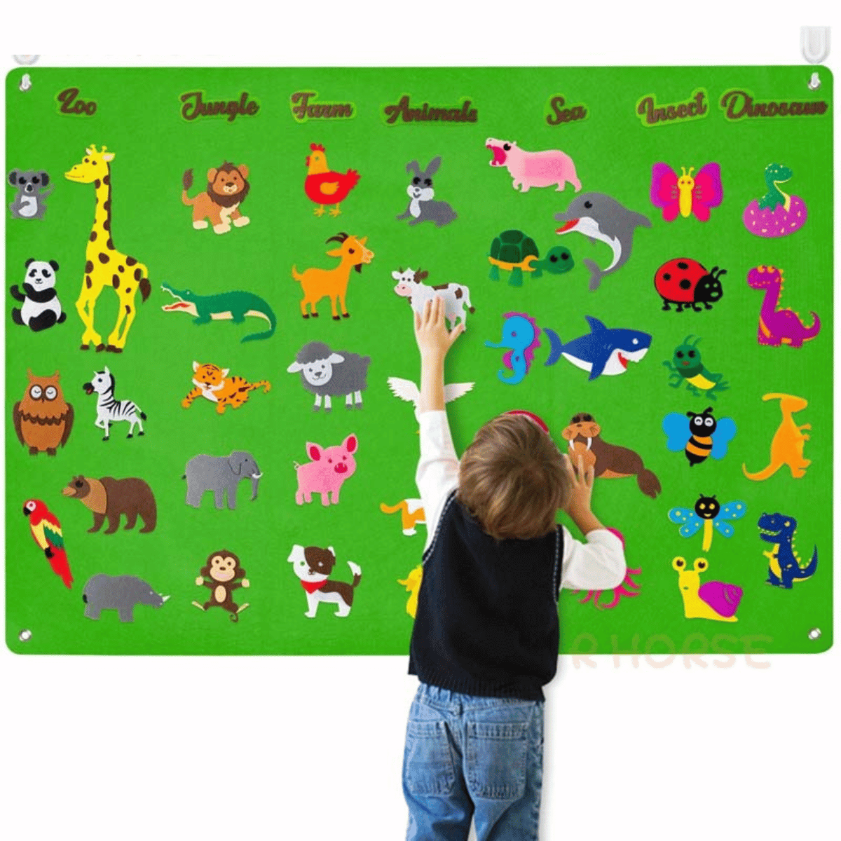 Kind spielt mit buntem Tier-Poster auf grünem Hintergrund, Lernspielzeug, Kinderzimmer-Dekoration.