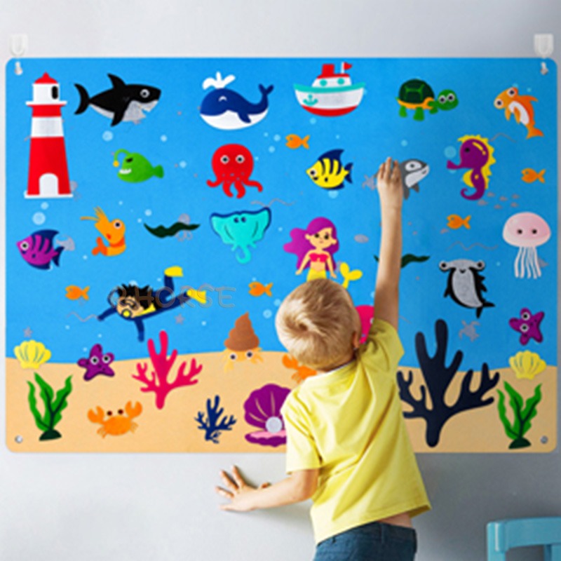Kind malt auf bunte Unterwasserwelt-Tafel mit Fischen, Korallen und Meerestieren.