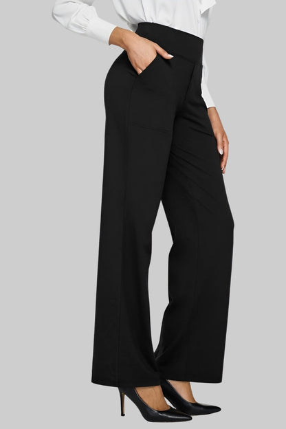 Schwarze Hose im Büro-Look, kombiniert mit weißer Bluse und schwarzen Pumps, Hand in der Seitentasche. 10