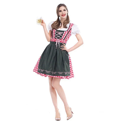 Frau im rot karierten Dirndl mit dunkelgrüner Schürze und weißer Puffärmelbluse hält ein Bierglas, Ganzkörperaufnahme von vorn. 1