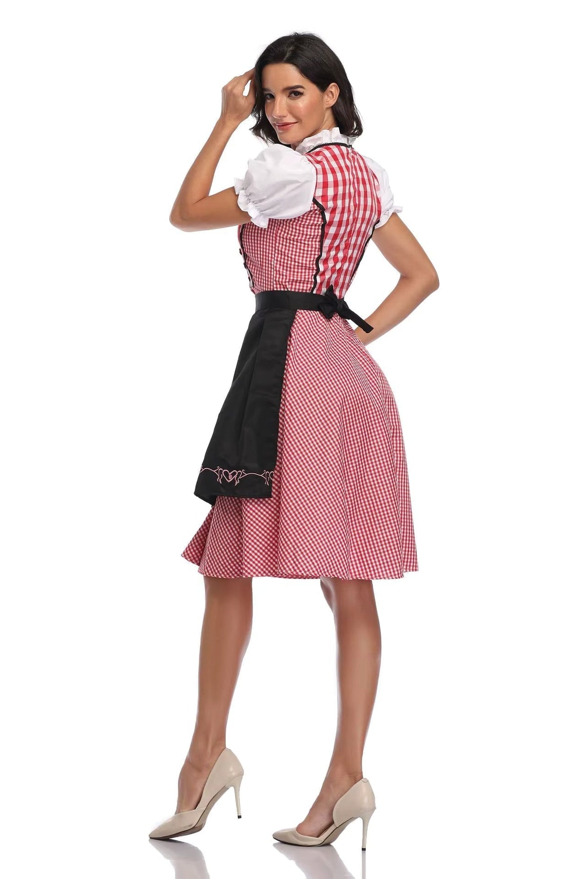 Rückansicht des rot-weiß karierten Dirndls mit schwarzer Schürze, großer Schleife und bestickter Schürzenkante, Model blickt über die Schulter. 2