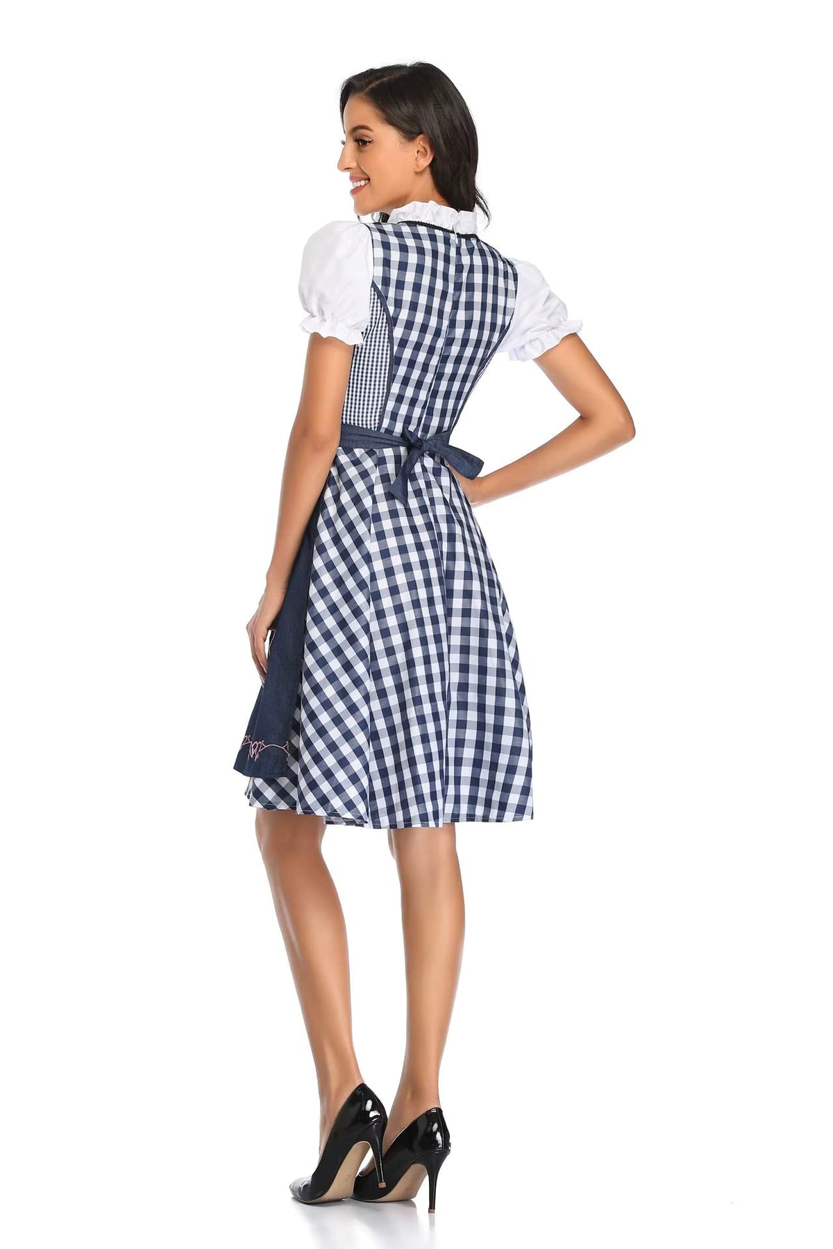 Rückansicht des Dirndls mit blau-weißem Karomuster, dunkelblauer Schürze mit Schleife und weißen Puffärmeln, das Model schaut zur Seite. 6