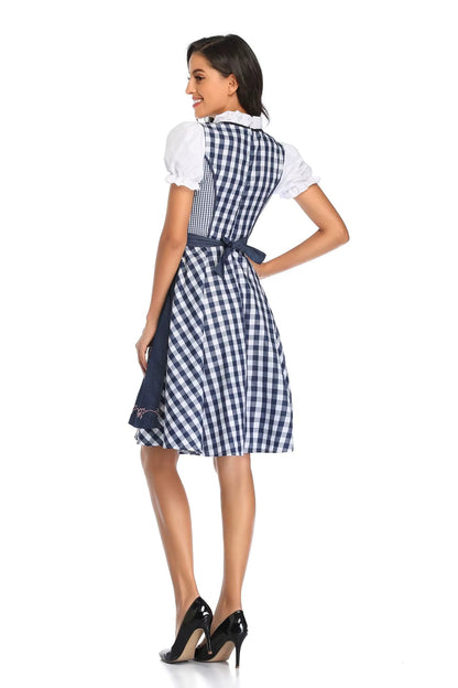 Rückansicht des Dirndls mit blau-weißem Karomuster, dunkelblauer Schürze mit Schleife und weißen Puffärmeln, das Model schaut zur Seite. 6
