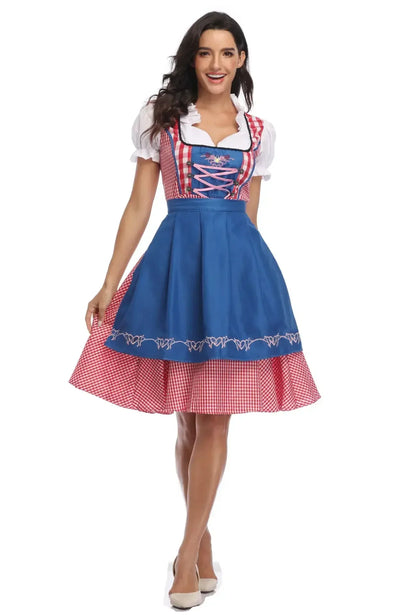Frontansicht des Dirndls mit leuchtend blauer bestickter Schürze, rosa Schnürung und rot kariertem Rock, das Model lüpft leicht den Rock. 7
