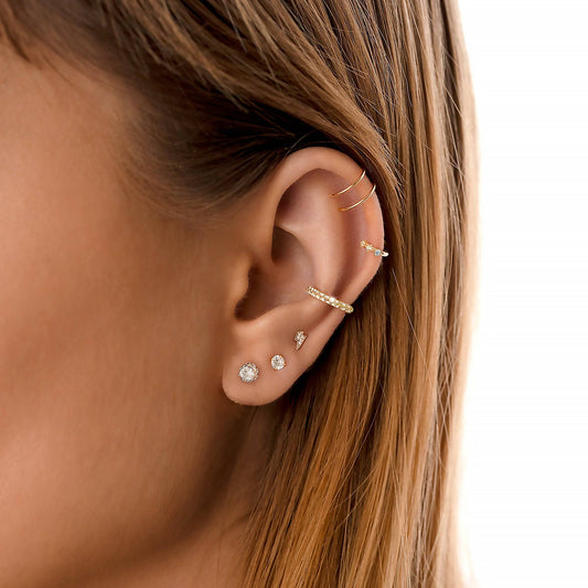 Frau mit goldenen Ohrringen und Piercings, Nahaufnahme, Schmuck, Modeaccessoires, stilvoll.
