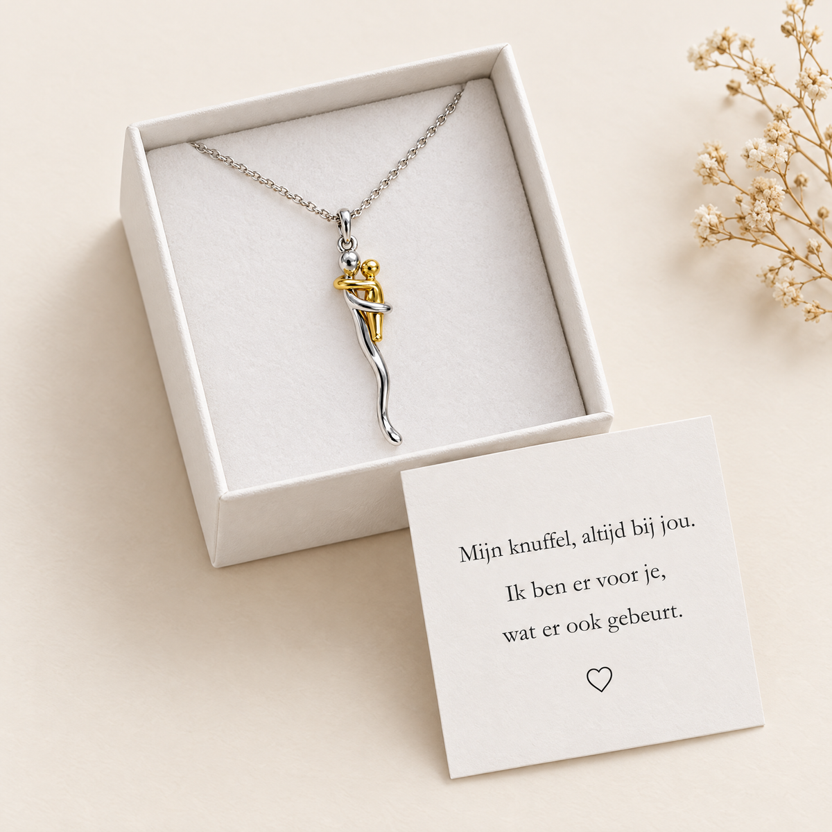 Die Halskette liegt auf weißem Samteinsatz in einer geöffneten Geschenkbox, daneben eine Karte mit Botschaft und ein Zweig Trockenblumen. 2