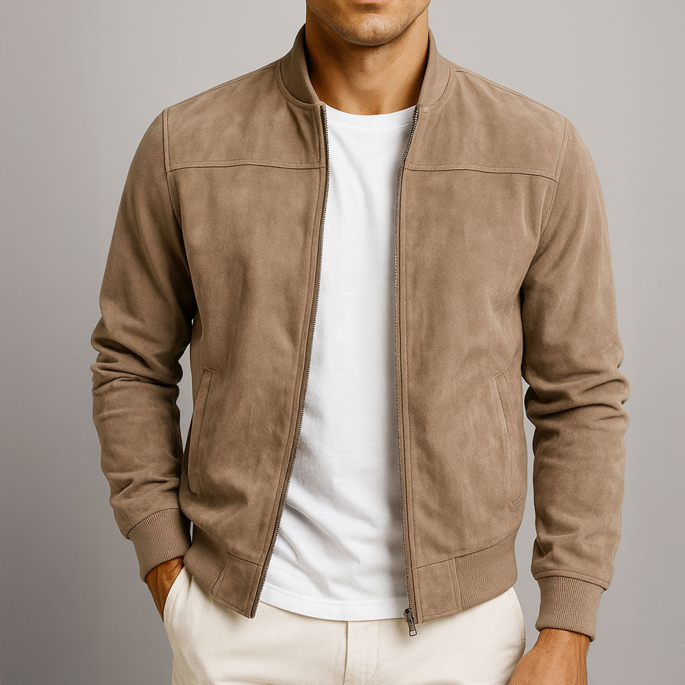 Mann trägt die offene Veloursleder-Optik-Jacke in Taupe über weißem T-Shirt, eine Hand in der Hosentasche, Frontansicht mit Rippbündchen. 1