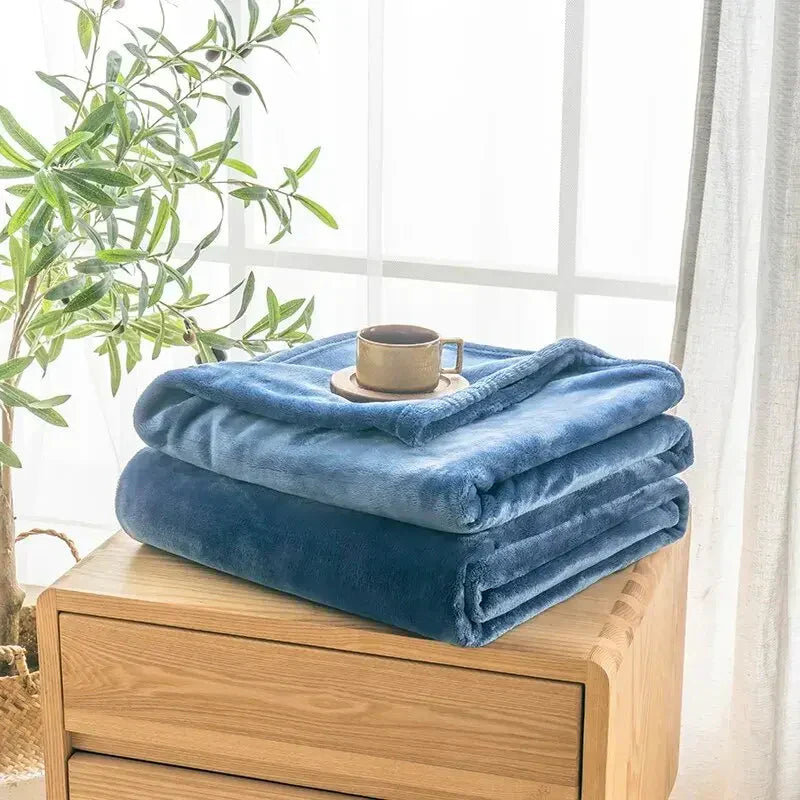 Blaue Fleecedecke auf Holztisch, Kaffeetasse, Fenster, Wohnzimmerdekoration, gemütlich.