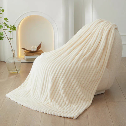 Cremefarbene, gerippte Decke aus Fleece auf Sessel, modernes Wohnzimmer, gemütliche Einrichtung.