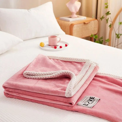 Rosa Kuscheldecke aus Fleece mit weißem Rand auf Bett, gemütliche Schlafzimmerdekoration.