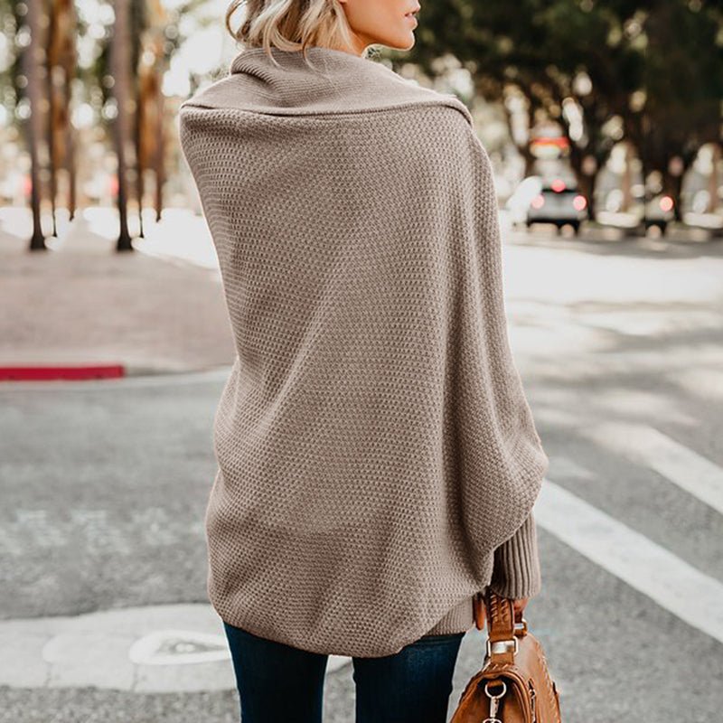 Frau in beiger Strickjacke auf Straße, modische Damenbekleidung, Herbstmode, Rückansicht.