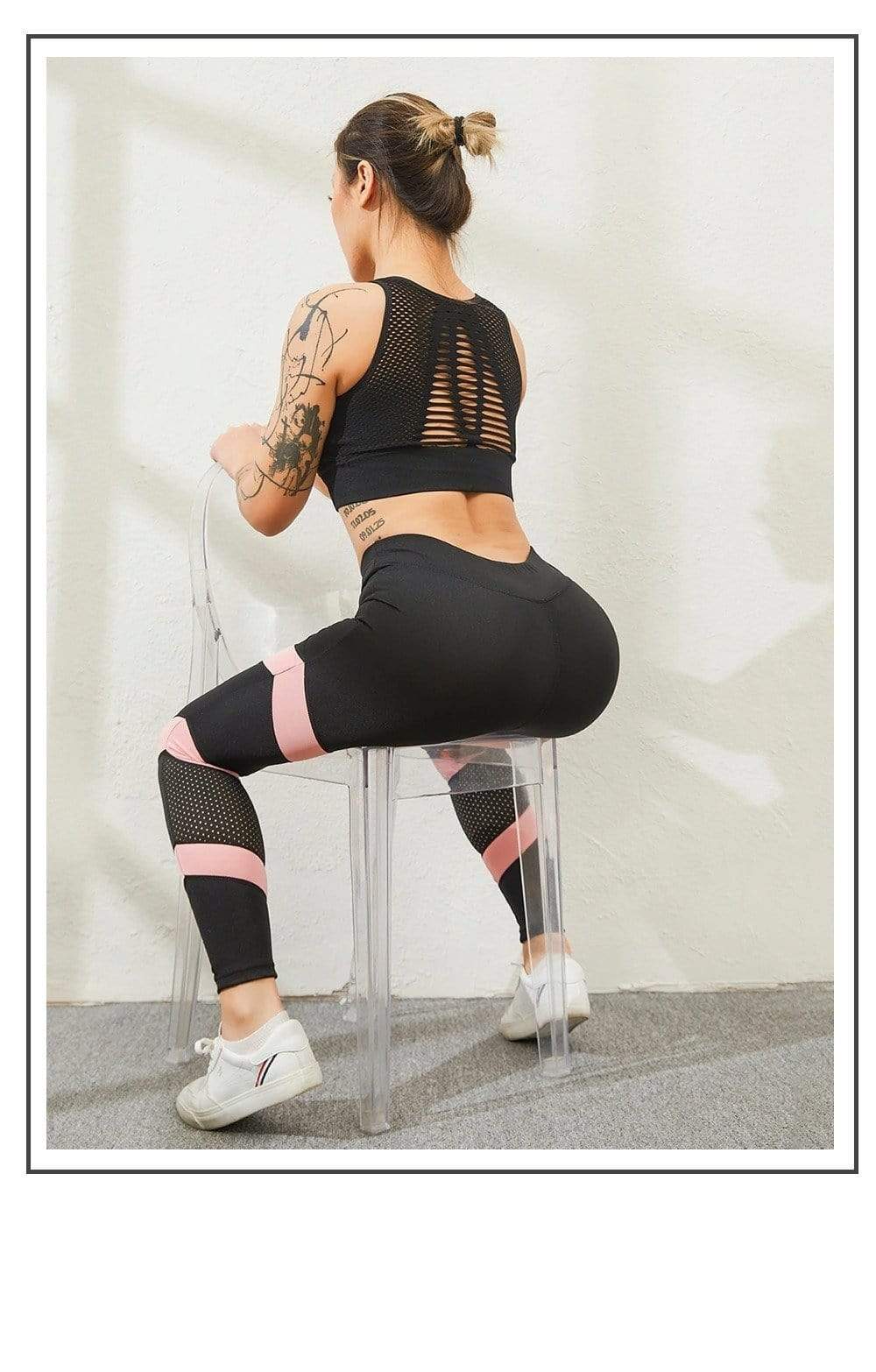 Frau in schwarzer Sportleggings und Top, trainiert auf transparentem Stuhl, Fitnessmode.