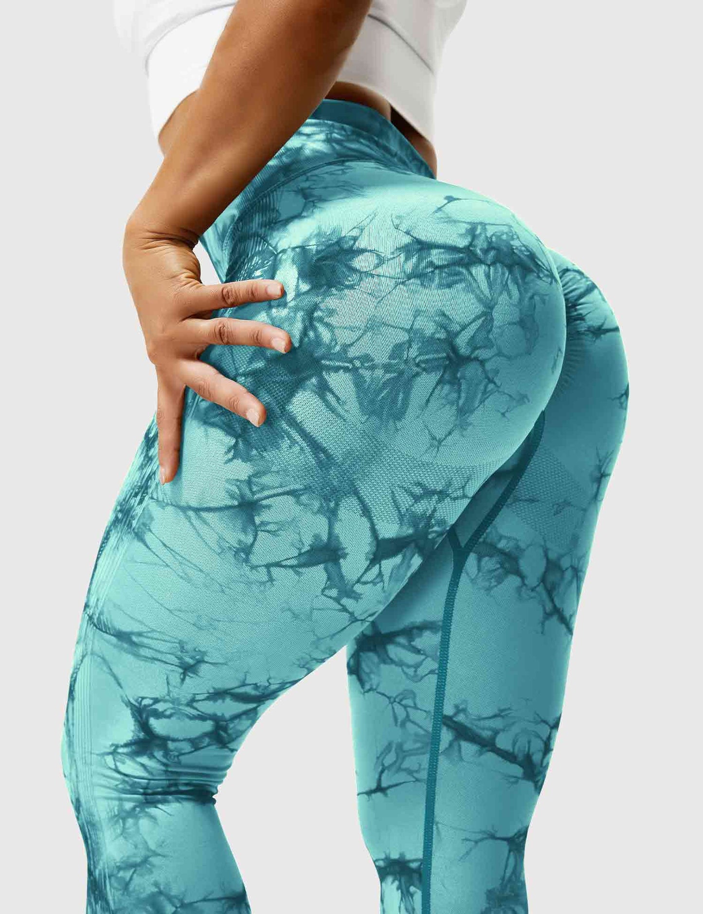 Frau in cyanblauen Leggings mit Marmormuster, Sportbekleidung, Fitnessmode.