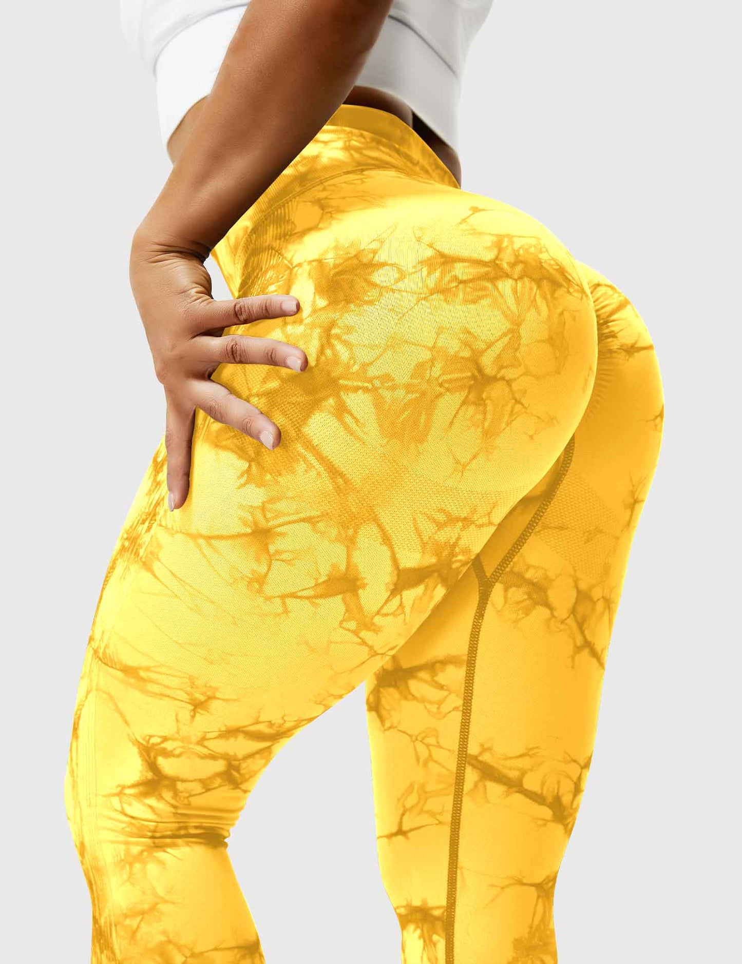 Frau in gelben Leggings mit Marmormuster, Sportbekleidung, Fitnessmode, elastisch, bequem.