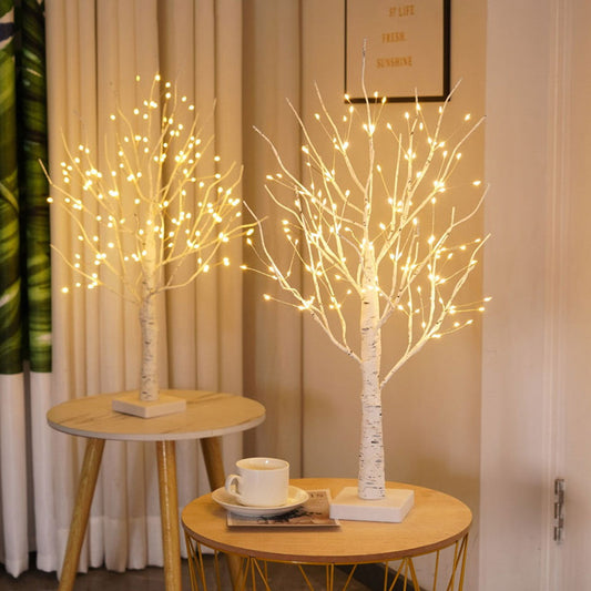 Zwei LED-Baumlichter auf Holztischen, warmweiß leuchtend, dekorative Beleuchtung, Innenraum.