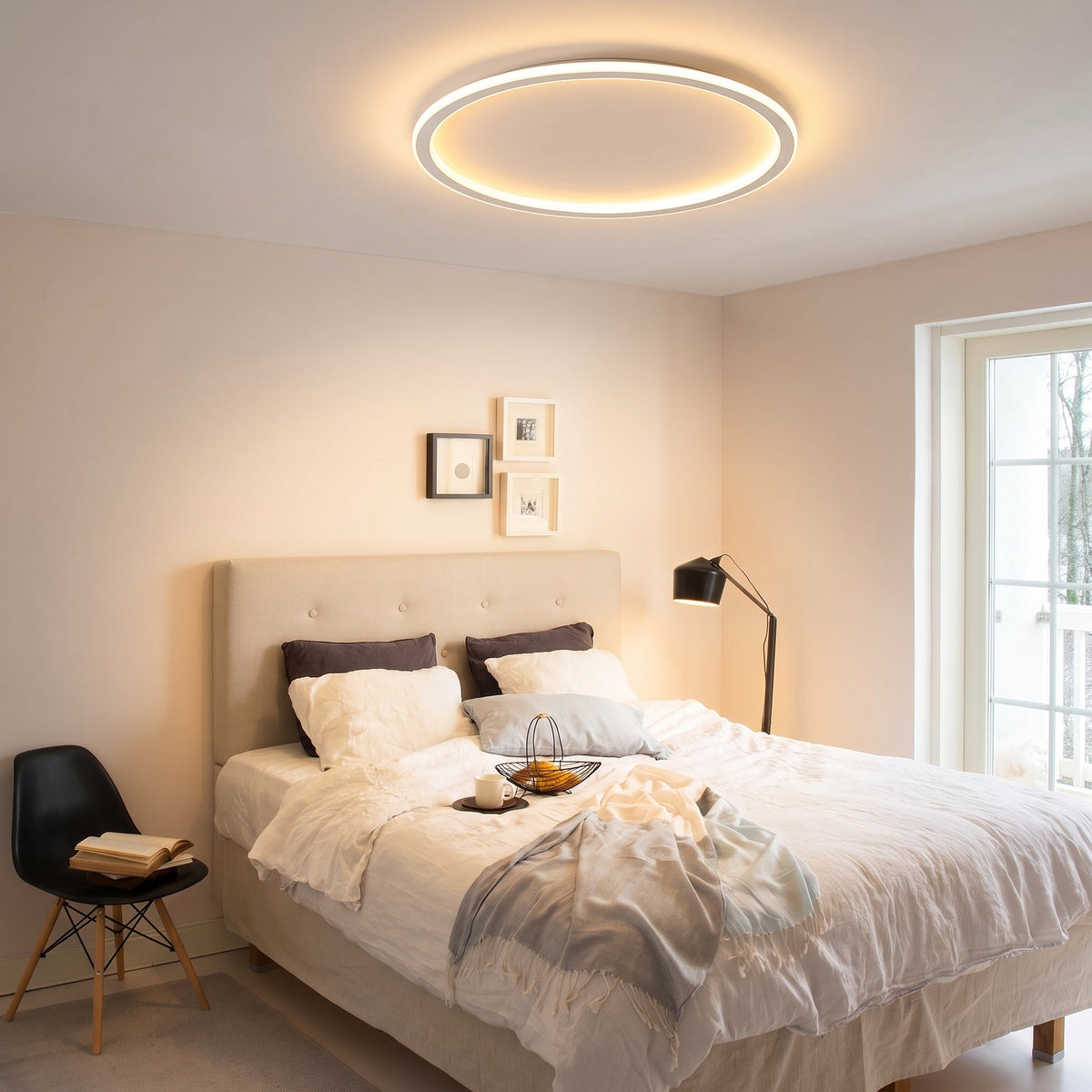 Deckenleuchte mit leuchtendem Ring über einem Schlafzimmerbett mit hellem Polsterkopfteil, Stehlampe und Stuhl. 9
