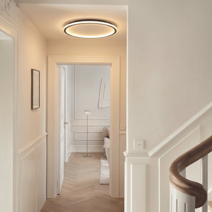 Flache Ringleuchte an der Decke eines hellen Flurs mit Stuckdetails, Fischgrätparkett und Holztreppengeländer. 5