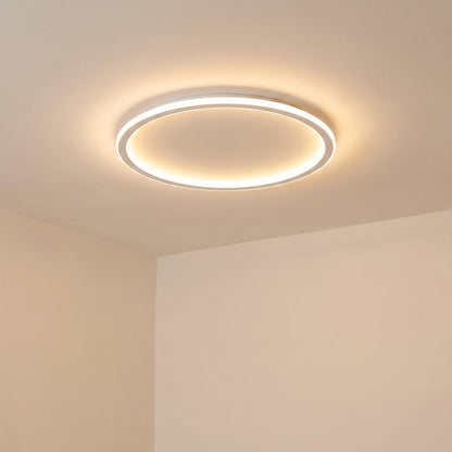 Eingeschaltete Ringleuchte an der Decke in der Raumecke, schräg von unten gesehen, mit warmem Streulicht auf den Wänden. 6