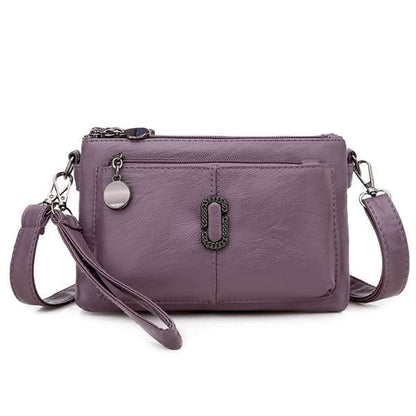 Lila Damenhandtasche aus Leder mit Reißverschluss und abnehmbarem Schulterriemen.
