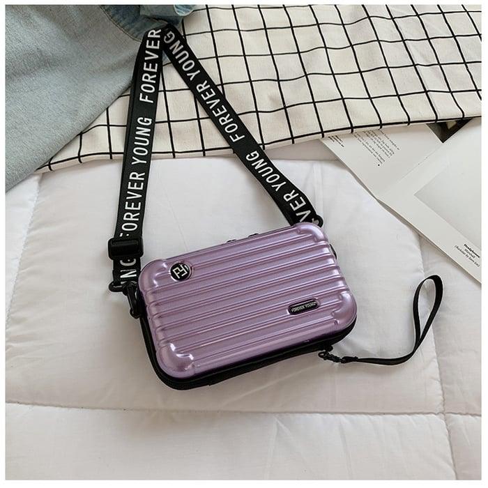 Lila Mini-Koffer-Handtasche für Damen, mit Schriftzug "Forever Young", modisch und kompakt.