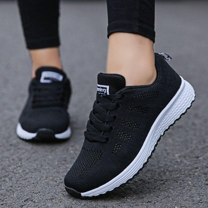 Schwarze Damen-Laufschuhe mit weißer Sohle, atmungsaktives Mesh, ideal für Sport und Freizeit.