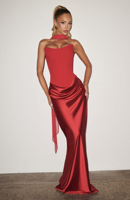 Rotes Korsettkleid mit Chiffonschal, Model mit hohem Zopf vor heller Wand, Hand an der Hüfte 14
