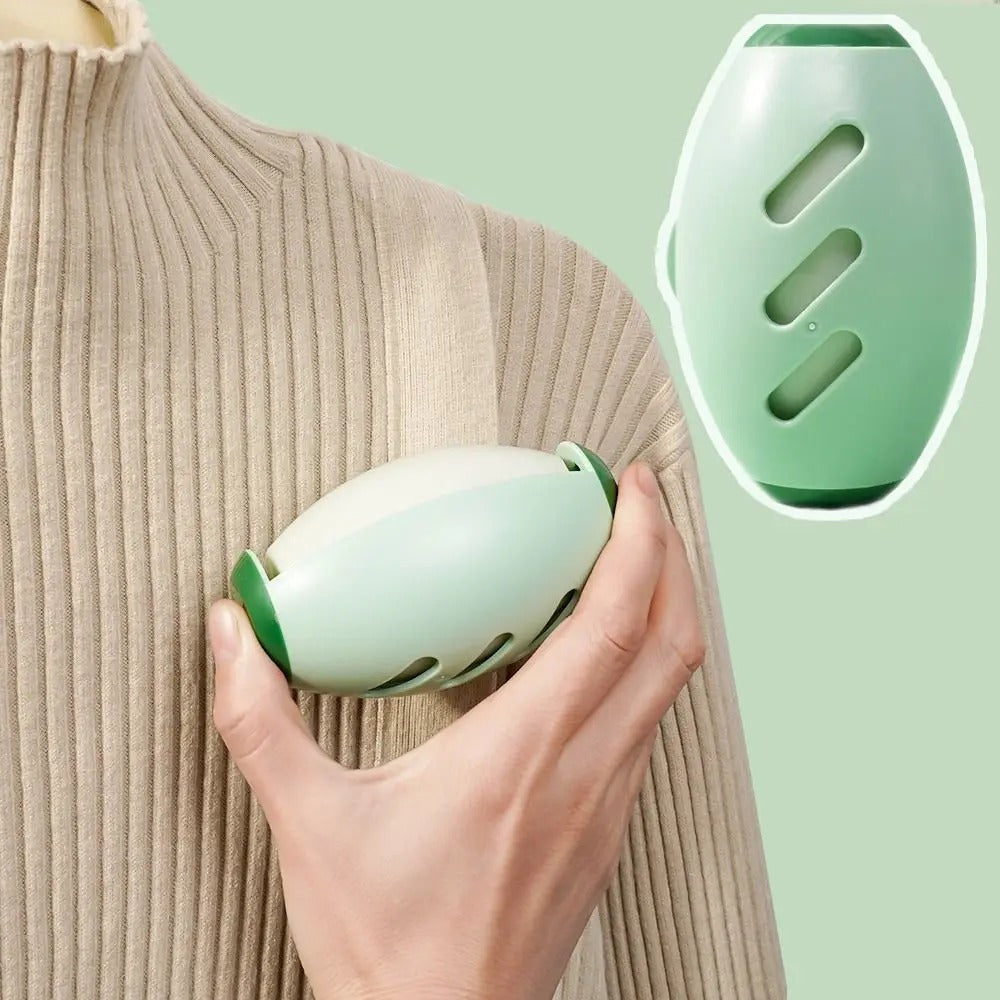 Grüner tragbarer Massagegerät, ergonomisch, für Schulterentspannung, auf beigem Pullover.