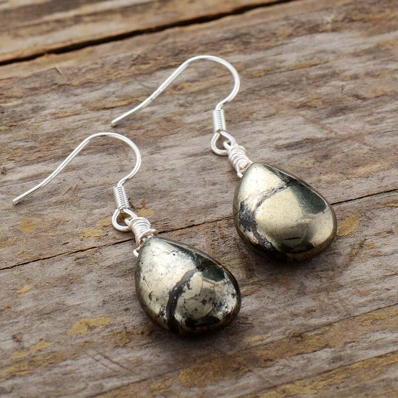 Teardrop-Ohrringe aus Pyrit, eleganter Schmuck für Damen, Geschenkidee, auf Holzoberfläche.