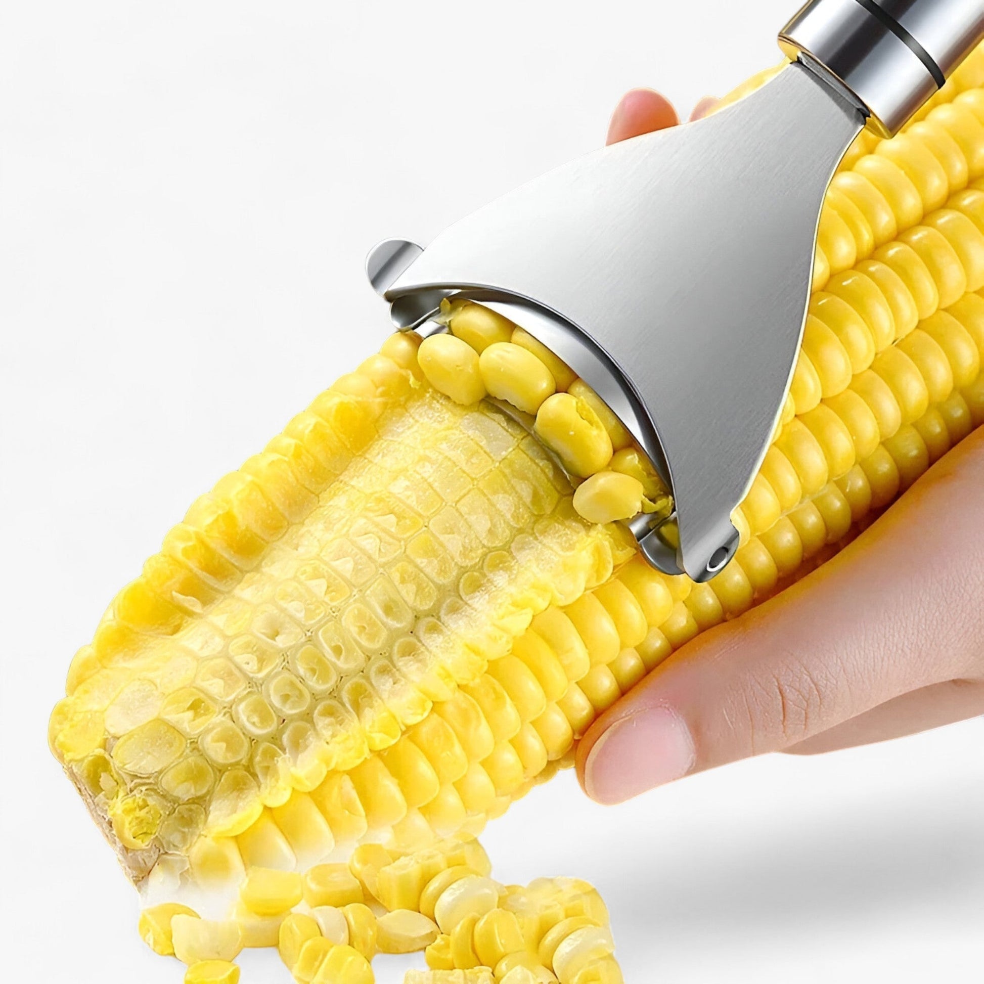 Hand hält Maiskolben mit Edelstahl-Maisentferner, gelbe Maiskörner, Küchengerät.