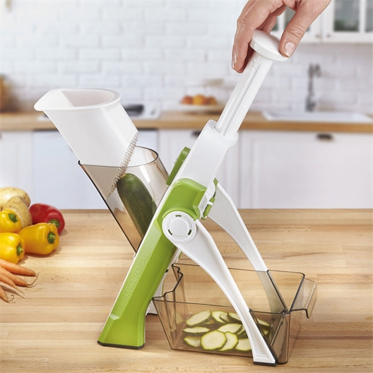 Grüne Mandoline Gemüseschneider in Küche, schneidet Zucchini in Scheiben, Kunststoff, ergonomisch.