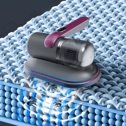 Tragbarer Staubsauger für Textilien, grau-rosa, entfernt Staub von blauer Stoffoberfläche.