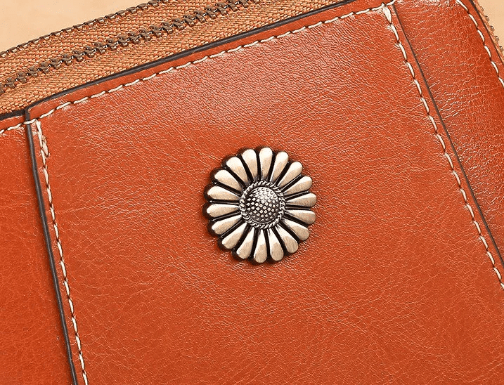 Nahaufnahme der silberfarbenen Blumen-Zierniete auf braunem Leder mit hellen Ziernähten 4