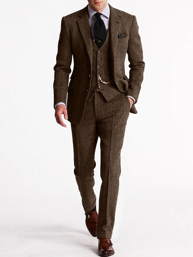 Model im dunkelbraunen Tweed-Dreiteiler mit Weste und Uhrenkette, Hand in der Hosentasche, Ganzfigur von vorn 3