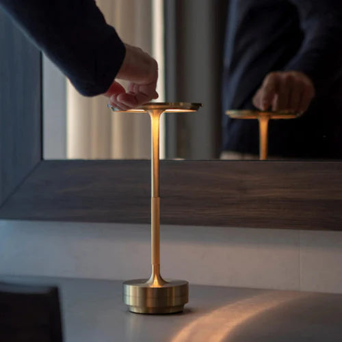 Goldene Metall-Touchlampe auf Tisch, modernes Design, dimmbar, ideal für Wohnzimmerbeleuchtung.