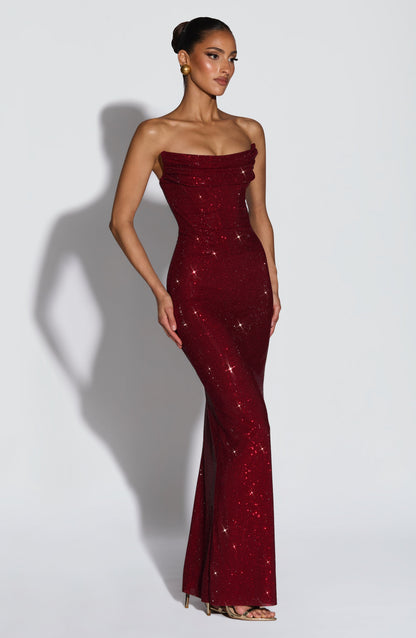 Dunkelrotes Maxikleid in seitlicher Dreiviertelansicht an einem Model, der körpernahe Schnitt und der Strassbesatz sind gut zu sehen. 4