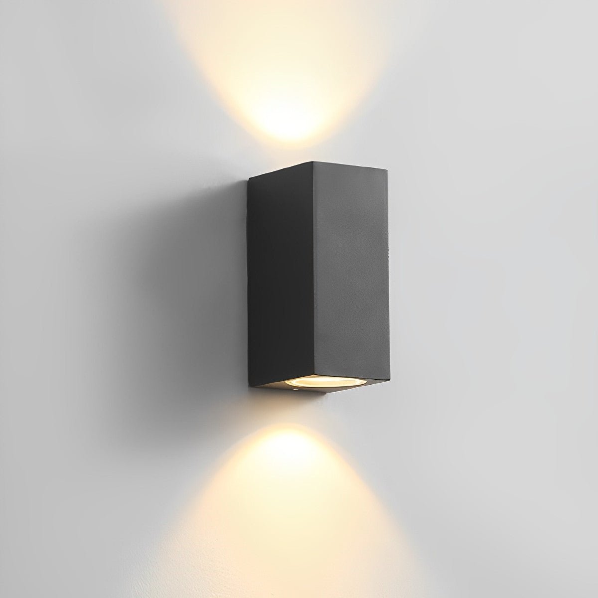 Schwarze rechteckige Wandleuchte mit Licht nach oben und unten an heller grauer Wand 12