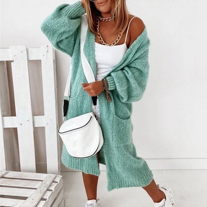Frau in grüner Strickjacke, weißem Top und Tasche, modisch, bequem, lässiger Stil.