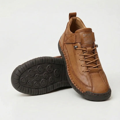 Brauner Ledersneaker mit Schnürung und Zierstichen, ein Schuh gekippt mit dunkler Sohle und rundem Noppenmuster sichtbar. 4