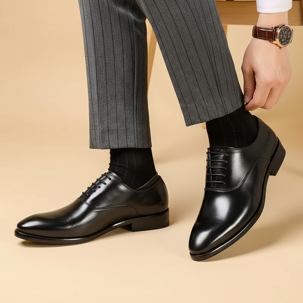 Schwarze Lederschnürschuhe von der Seite getragen, Mann in grauer Nadelstreifenhose rückt sein Hosenbein zurecht 3