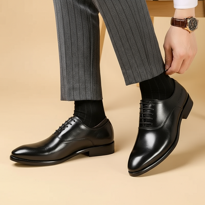 Schwarze Lederschnürschuhe von der Seite getragen, Mann in grauer Nadelstreifenhose rückt sein Hosenbein zurecht 3