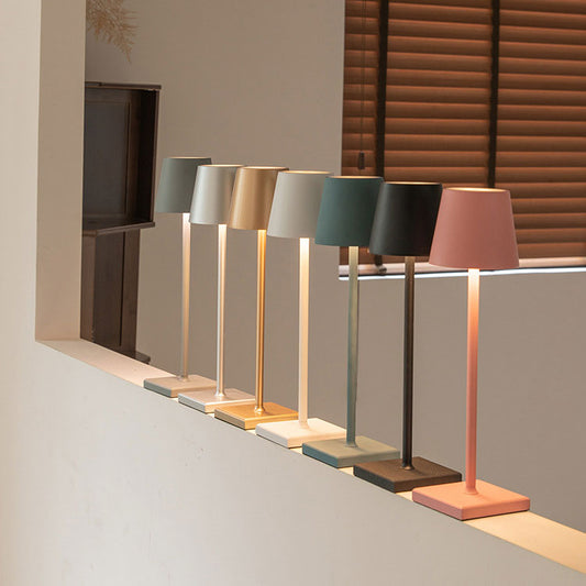 Sechs moderne Tischlampen in verschiedenen Farben auf einer Fensterbank, minimalistisch, LED.