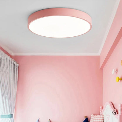 Rosa runde Deckenleuchte ohne Holz in einem rosa gestrichenen Kinderzimmer mit Vorhang und Bettdetails. 5