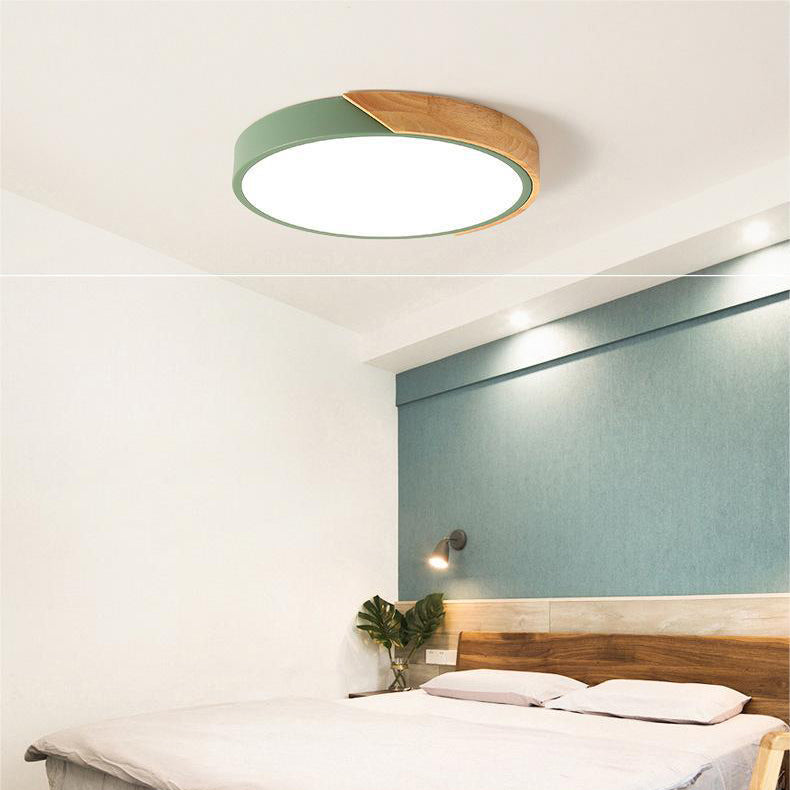 Grüne Deckenleuchte mit Holzsegment über einem Bett mit Holzkopfteil, blaugrüner Wand und Wandleuchte im Schlafzimmer. 6